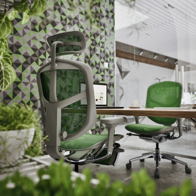 An office space with a coworking wooden desk. One on side is the Enjoy Elite with a legrest and headrest. The other side has an Enjoy office chair without. Both office chairs have a grey frame and green mesh.