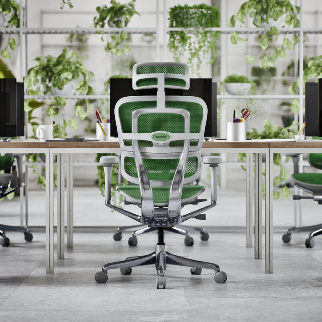 Back view of the Ergohuman designer office chair in a grey frame and green mesh. The chair is at a desk in a white modern office space full of vibrant greenery. A great office chair for modern workspaces.