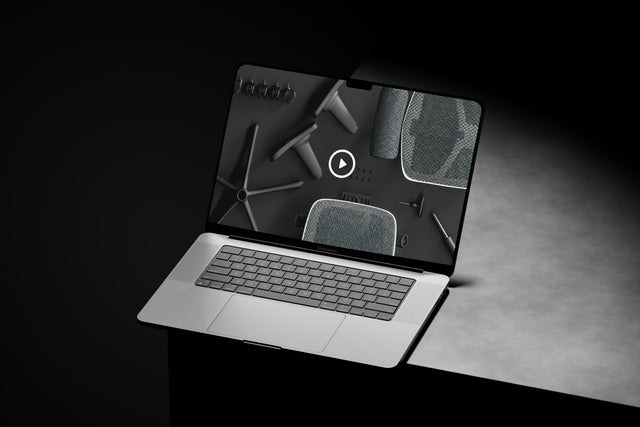 Laptop on a grey surface with the Enjoy Ultra gaming chair assembly guide video open
