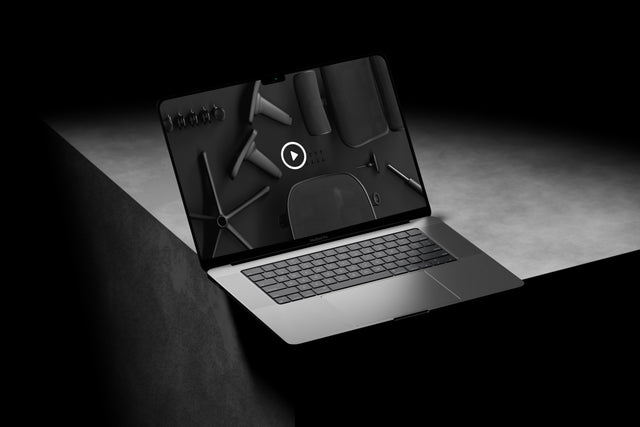 Macbook Pro on her laptop, looking at the Ergohuman ergonomic office chair assembly guide video