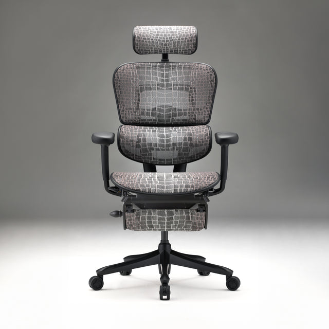 Front view of ergonomic gaming chair, Ergohuman Carbon, in black frame with grey carbon fibre detailed mesh. The chair is in a grey room with white flooring and grey background.