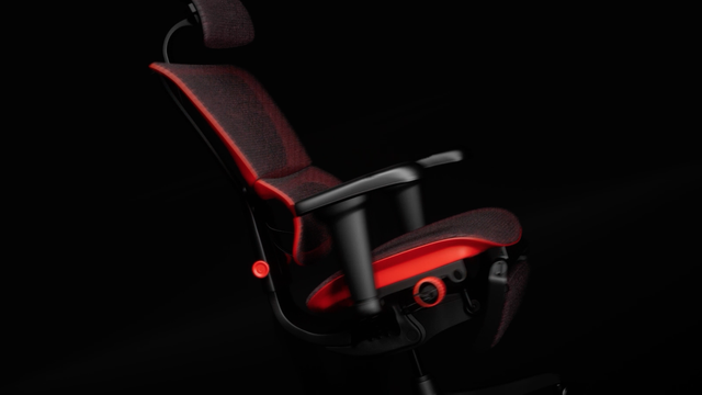 A red gaming chair with black mesh upholstery is reclining.