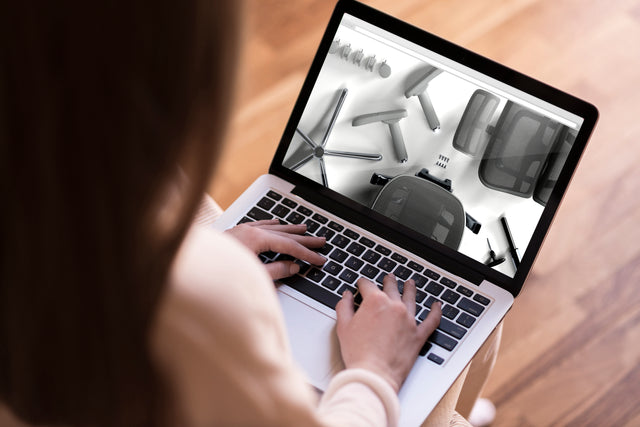 Over the shoulder shot of a woman on her laptop, looking at the Ergohuman ergonomic office chair assembly guide video 